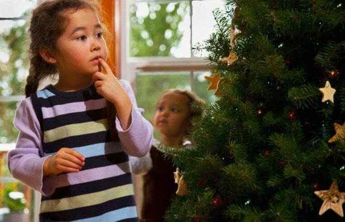dekleta, ki krasijo božično drevo