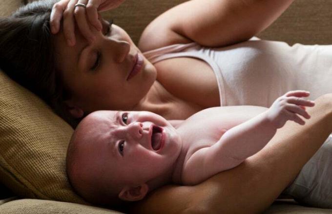 mãe estressada segurando bebê