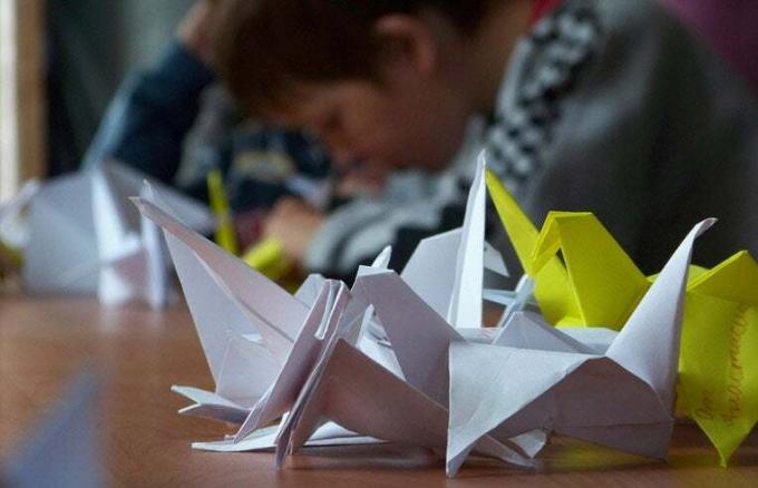 criança fazendo origami
