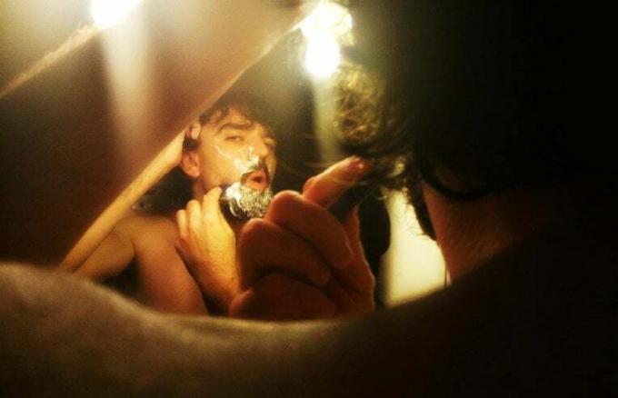 muž holiaci sa pred zrkadlom