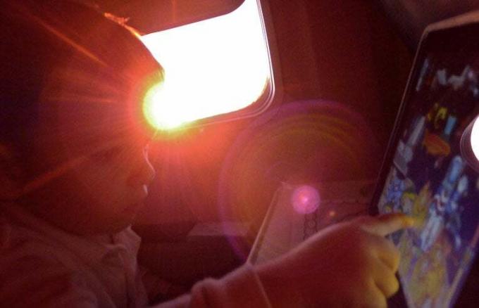 ребенок использует iPad в самолете