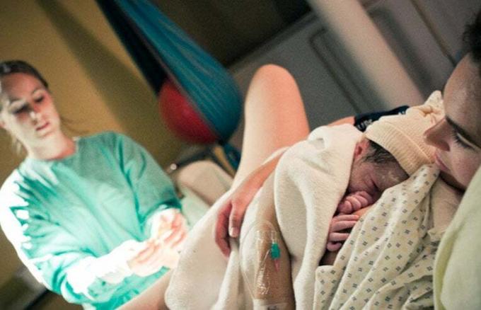 mãe segurando filho recém-nascido pela primeira vez