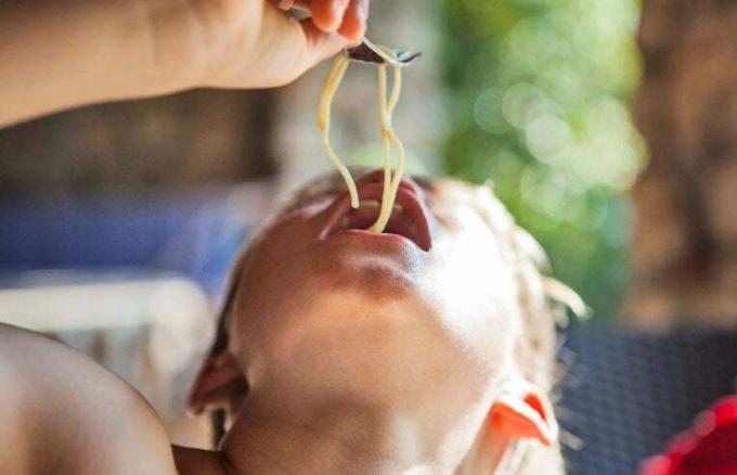 anak laki laki makan spageti