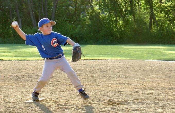 niño lanzando béisbol