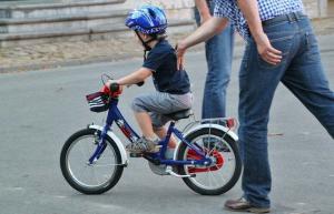 子供たちにブロックの周りで一人で自転車に乗らせる