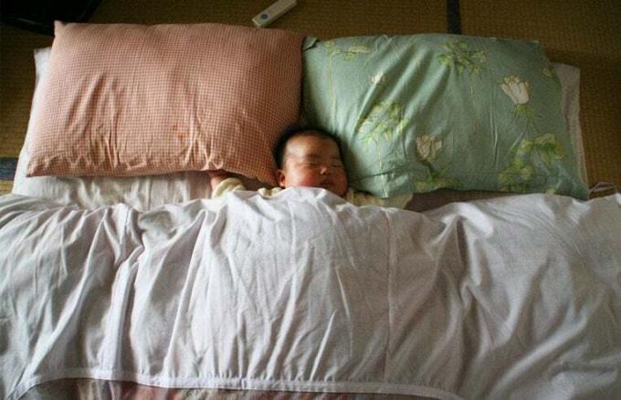 dieťa vo veľkej posteli
