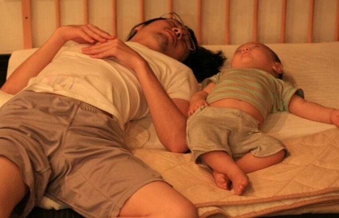 赤ちゃんと一緒に寝ている父