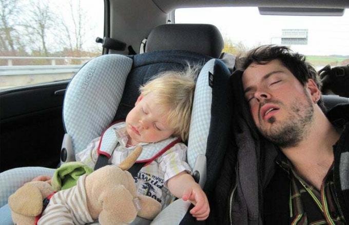 far och barn sover i baksätet i bilen