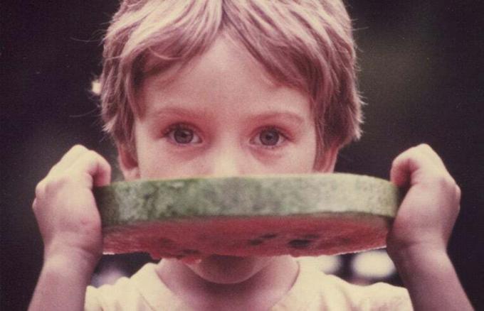 enfant mangeant une tranche de pastèque