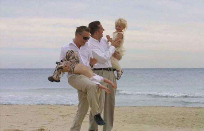 homofile pappaer på stranden med barn