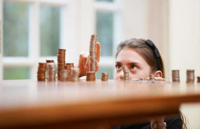 дівчина рахує стопки монет