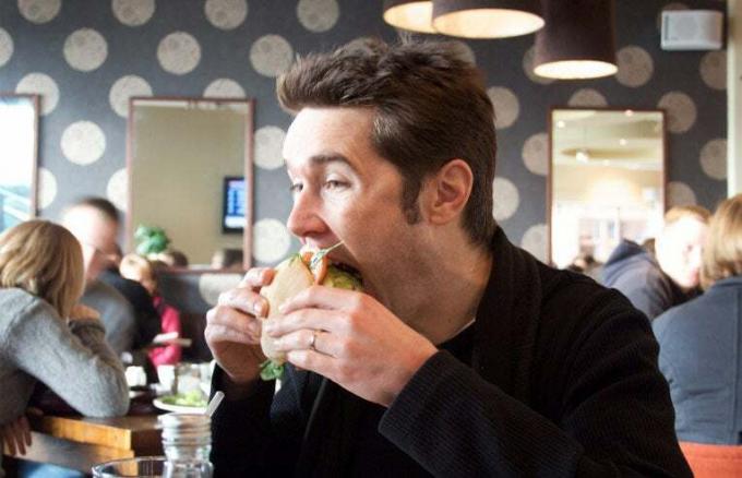 homme mangeant un hamburger
