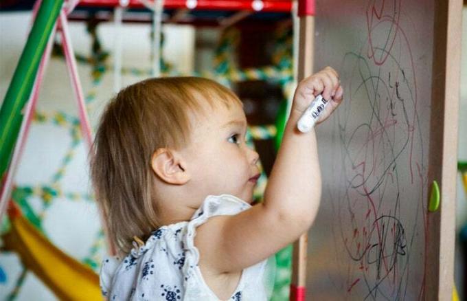 Kleinkind zeichnet auf Whiteboard