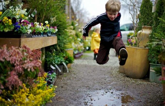 Kind springt over een plas